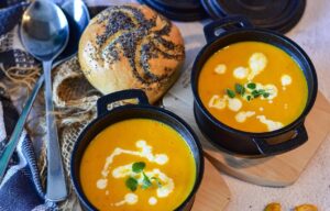2 bowls of autumnal meals pumpkin soup with bread